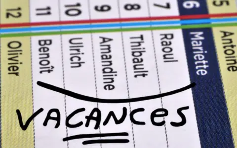 Calendrier avec noms et le mot "VACANCES" écrit à la main.
