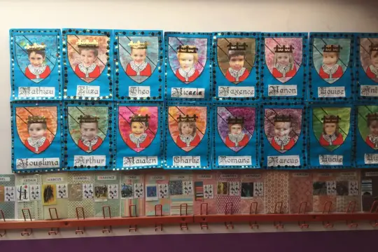 Portraits d'enfants couronnés, résultat d'une activité manuelle moyen âge maternelle. Chaque enfant est représenté sur un blason.