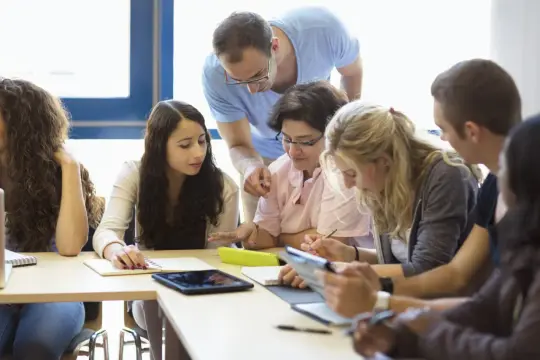 Des étudiants travaillent en groupe, un professeur les aide. Bafd combien de temps pour finir ce projet ?