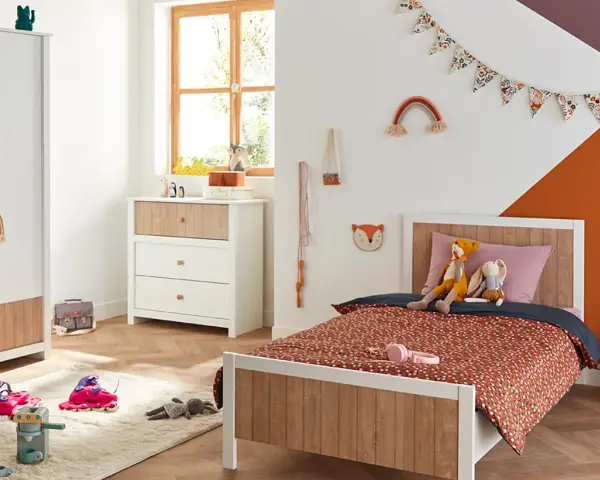 Chambre d'enfant décorée avec un lit, une commode, une armoire et des jouets.