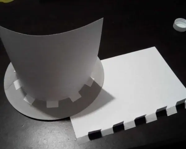 Chapeau en carton en cours de création, avec des pièces découpées et un patron.