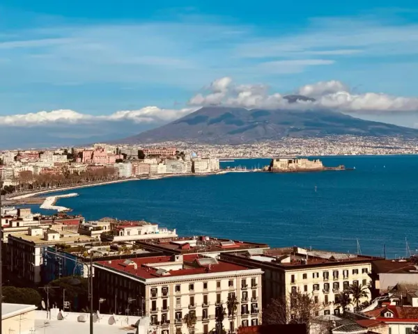 Vue panoramique de Naples avec le Vésuve en arrière-plan, un voyage inoubliable.