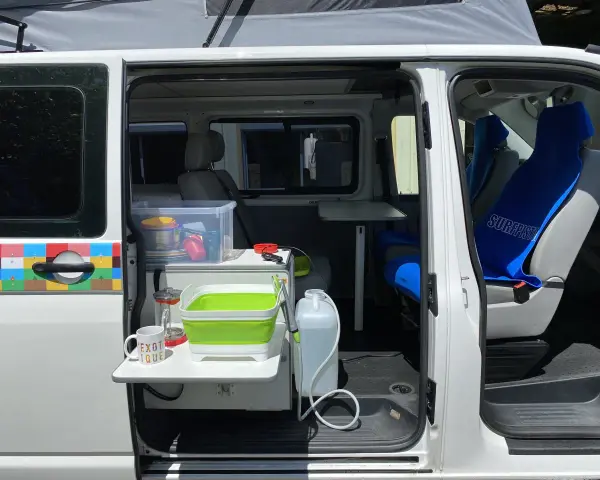 Aménagement intérieur d'un véhicule pour le transport de personnes moins de 9 places, avec coin cuisine et sièges.