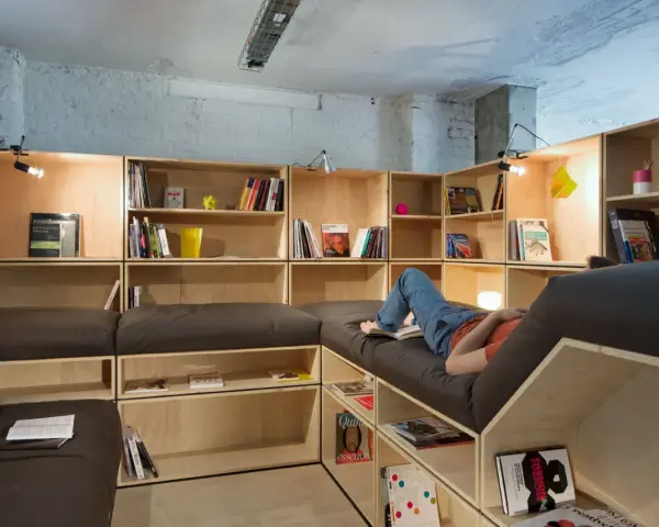 Aménagement d'une salle de loisirs avec étagères modulables et banquettes confortables.