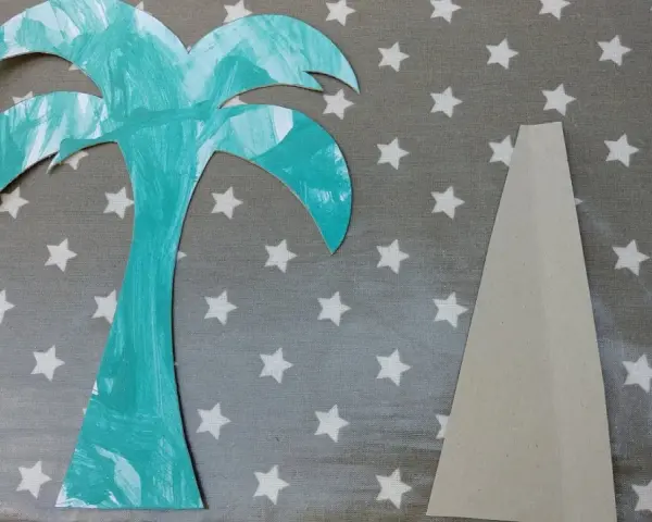 Palmier en carton turquoise et pièce de support beige sur fond étoilé.