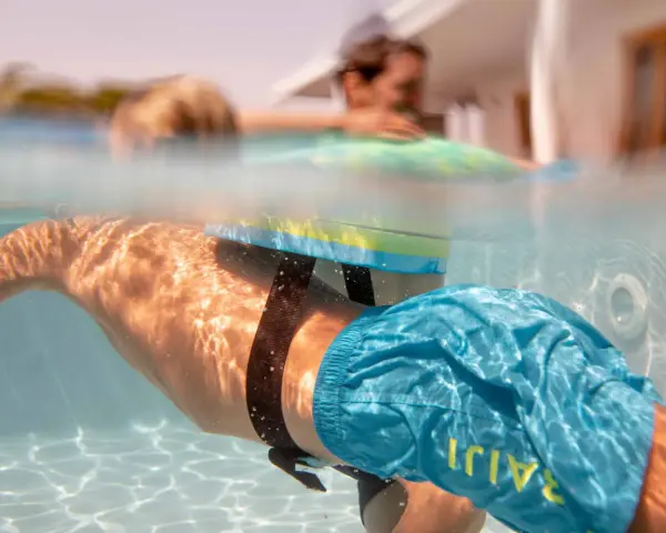 Plongeon sous-marin avec un dispositif de sécurité pour piscine, rappelant l'importance de la sécurité piscine réglementation pour tous.