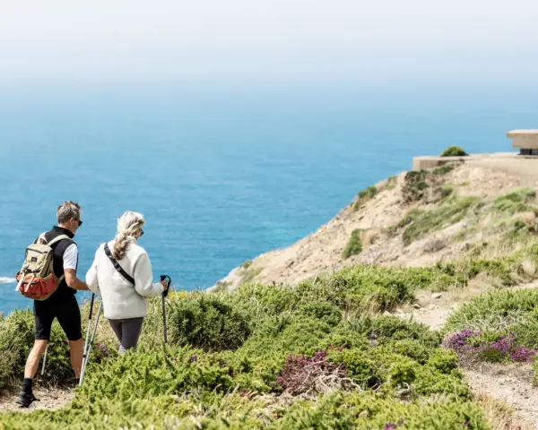 Couple randonnant sur les falaises de Jersey, profitant d'un séjour linguistique et d'une vue imprenable sur la mer.
