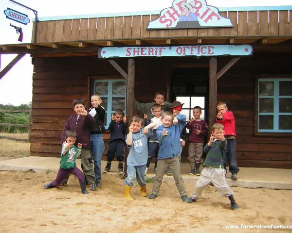 Groupe d'enfants devant un bureau de shérif western.