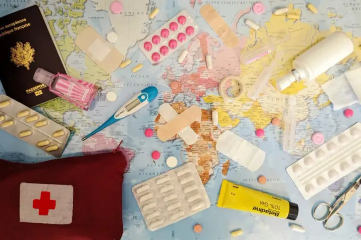 Une trousse de secours prête pour un voyage autour du monde : passeport, pansements, thermomètre, pilules, désinfectant et crème.