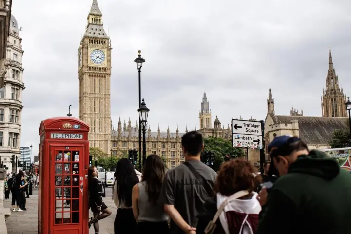Cabine téléphonique rouge, Big Ben et touristes à Londres.