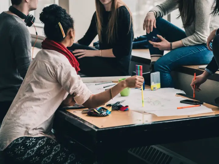 Groupe d'étudiants en formation uc direction bpjeps, travaillant sur un projet créatif avec des feutres et des schémas.