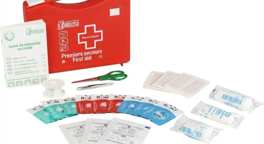 Trousse pharmacie bébé 2 ans : une trousse rouge de premiers secours avec pansements, compresses, ciseaux, pince à épiler et guide.