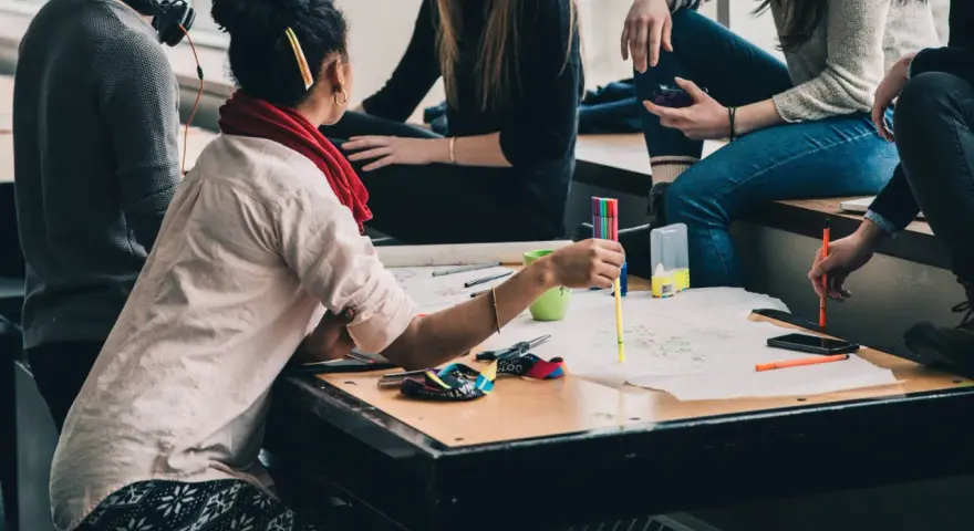 Groupe d'étudiants en formation uc direction bpjeps, travaillant sur un projet créatif avec des feutres et des schémas.