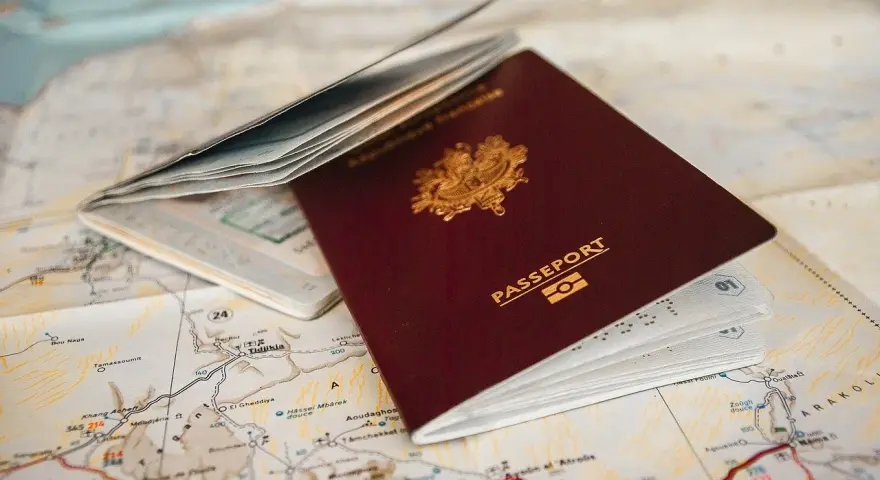 Un passeport français ouvert sur une carte. Pour aller à Rome, faut-il un passeport ? La réponse est oui si vous n'êtes pas citoyen de l'UE.