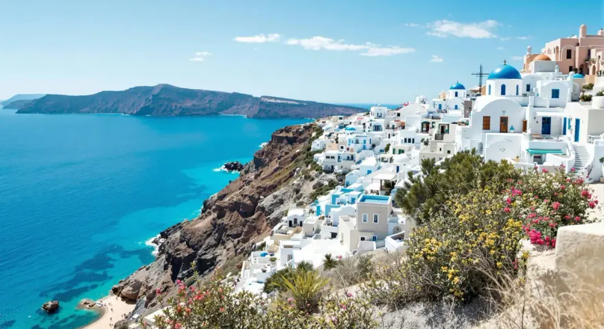 Vue panoramique de Santorin, Grèce, avec des maisons blanches et des dômes bleus surplombant la mer Égée.
