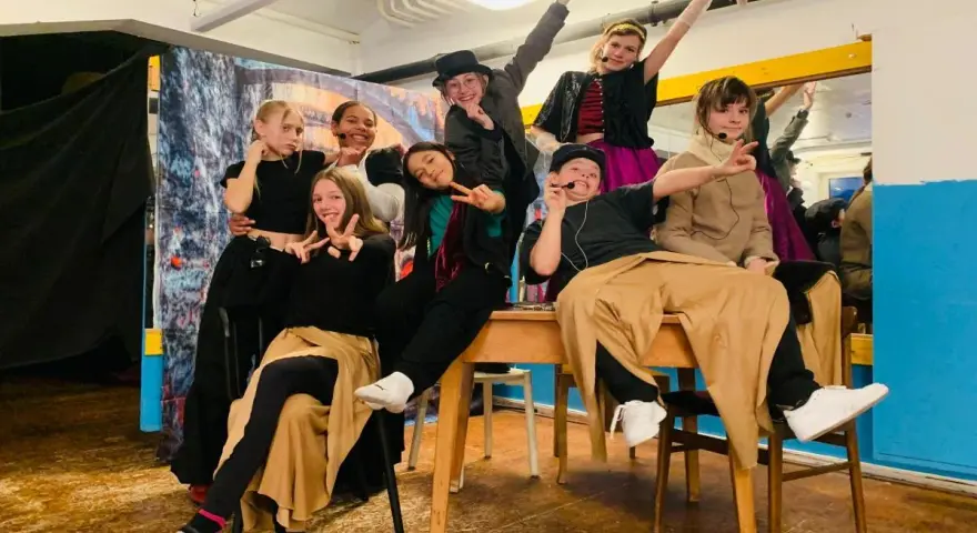 Des jeunes acteurs en costumes colorés, prêts pour une pièce de théâtre. Une joyeuse colonie de vacances artistique !