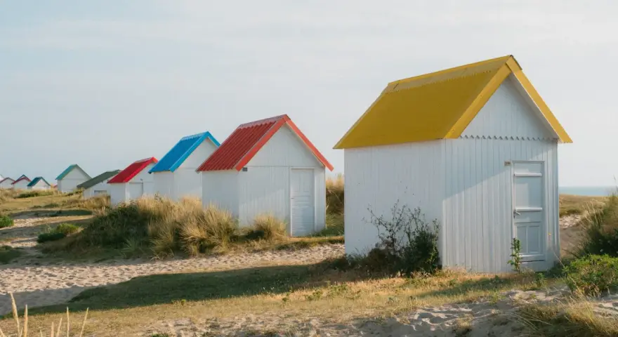 Cabanes de plage colorées à Gouville-sur-Mer : découvrez les activités nautiques et les promenades sur le sable.