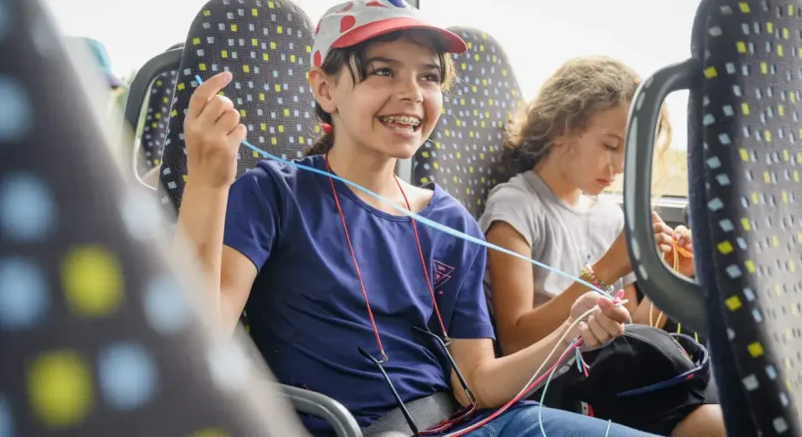 Deux enfants créatifs dans un bus, s'adonnant à une activité manuelle. Une belle illustration de l'éducation populaire en mouvement.