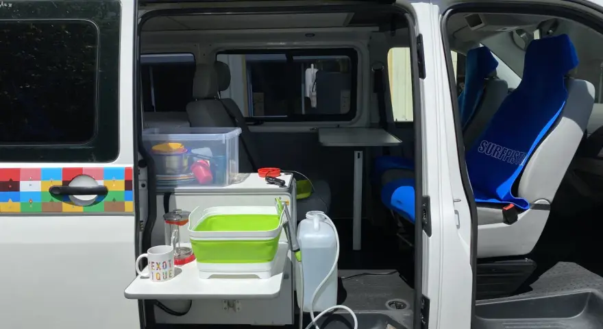 Aménagement intérieur d'un véhicule pour le transport de personnes moins de 9 places, avec coin cuisine et sièges.