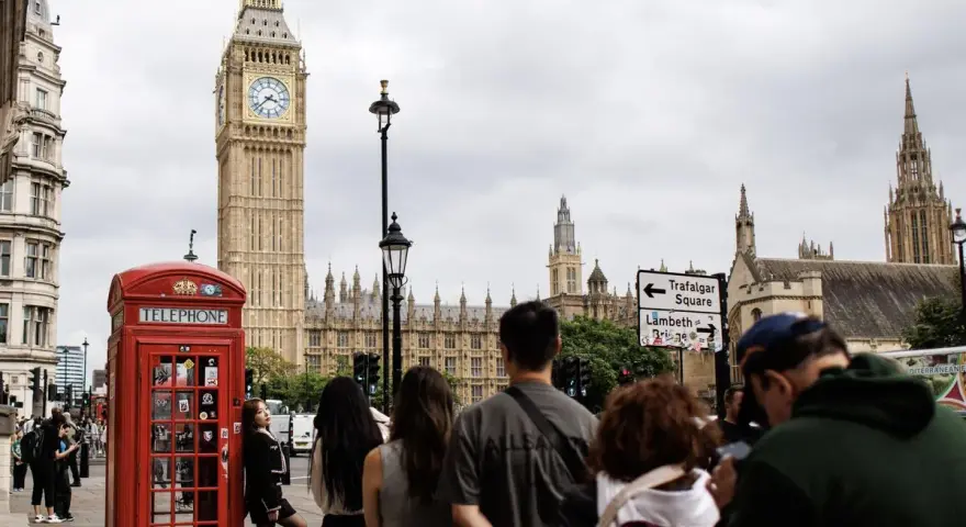 Cabine téléphonique rouge, Big Ben et touristes à Londres.