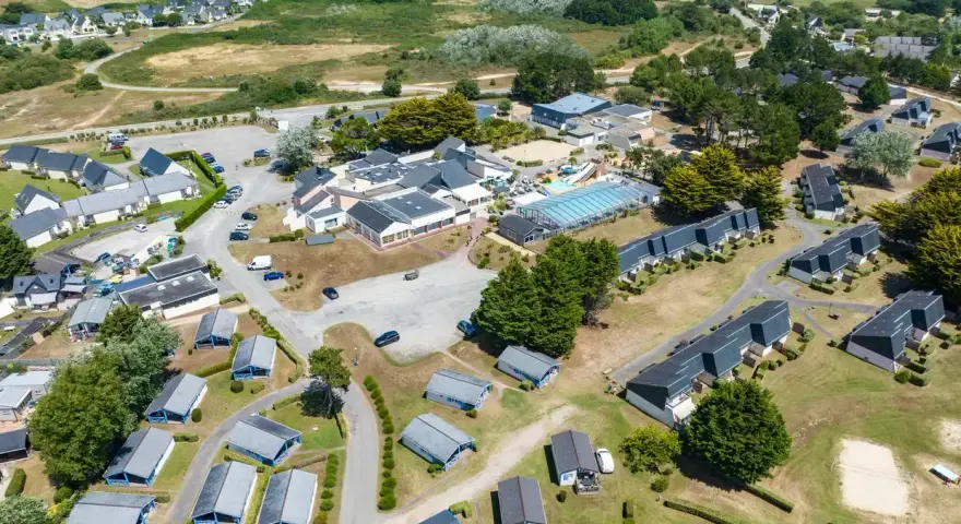 Vue aérienne d'une zone vacances Bretagne avec des maisons, une piscine et des espaces verts.