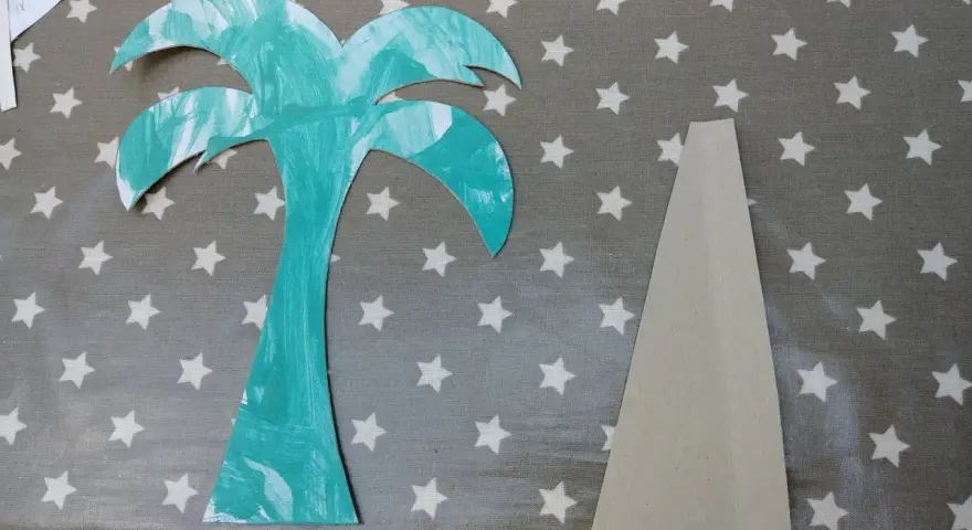 Palmier en carton turquoise et pièce de support beige sur fond étoilé.