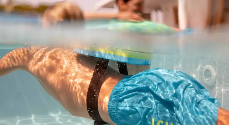 Plongeon sous-marin avec un dispositif de sécurité pour piscine, rappelant l'importance de la sécurité piscine réglementation pour tous.