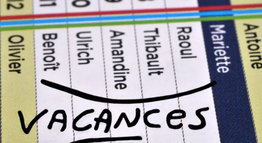 Calendrier avec noms et le mot "VACANCES" écrit à la main.