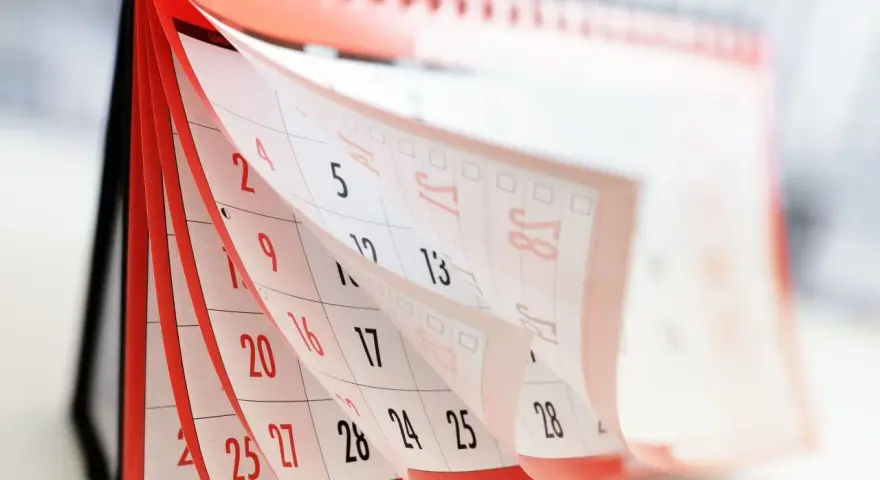 Calendrier de bureau avec pages qui tournent, montrant des dates.