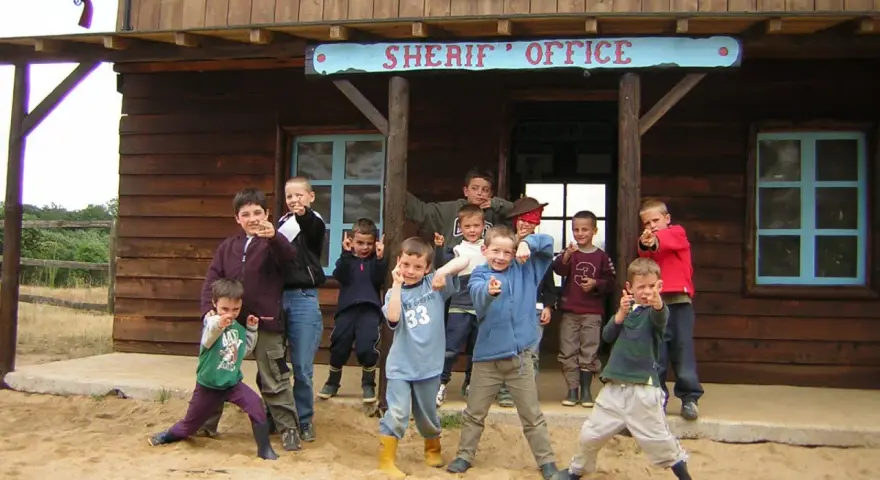 Groupe d'enfants devant un bureau de shérif western.