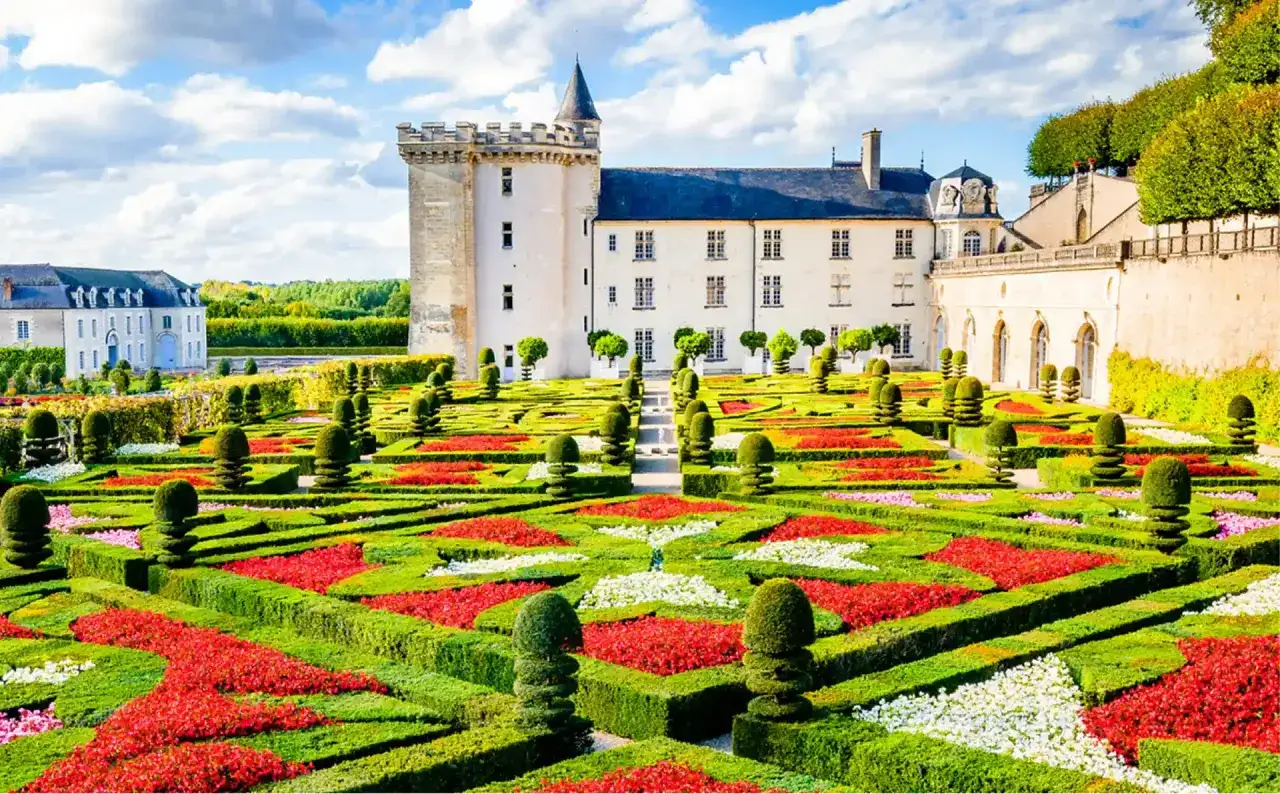 Jardins à la française colorés devant un château, un lieu idéal pour une colonie de vacances en Indre-et-Loire.