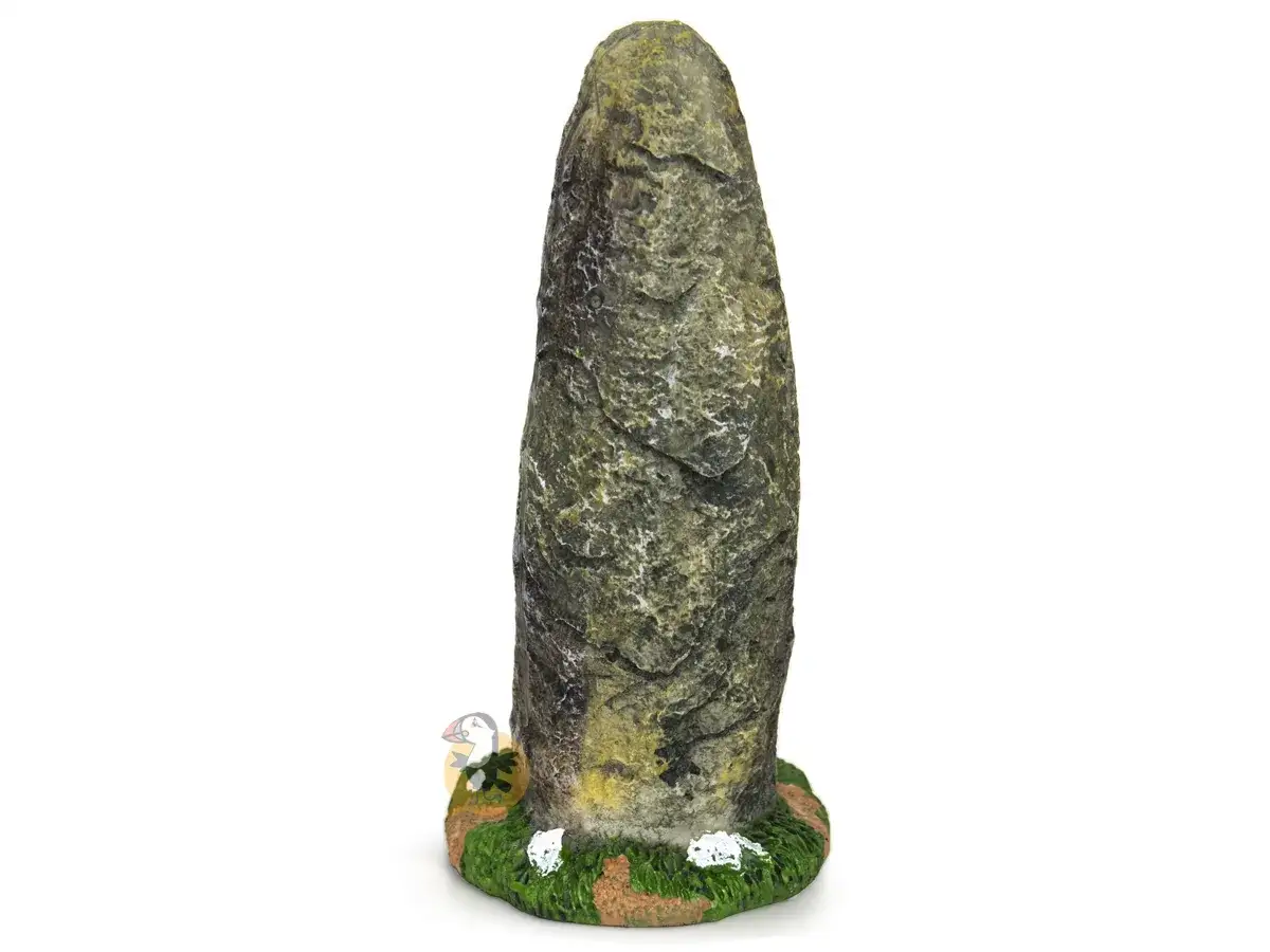 Un petit personnage observe un menhir en carton, habilement décoré pour ressembler à de la pierre.