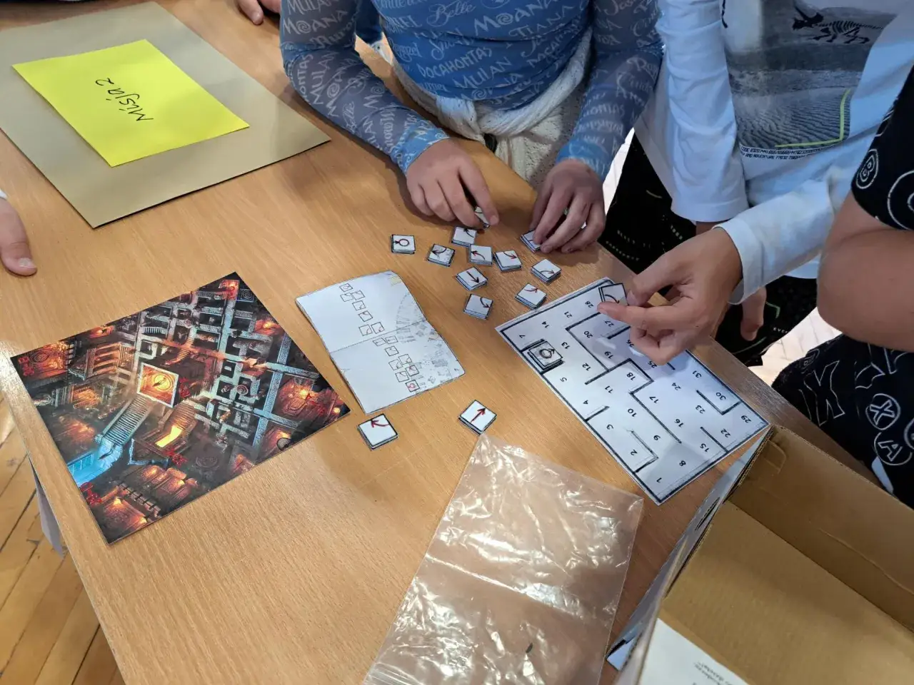 Des adolescents jouent à un jeu de plateau, résolvant une devinette ado dans un labyrinthe.